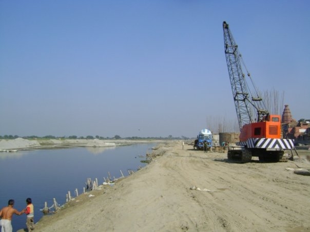 Строительная техника и насыпи на берегу Ямуны